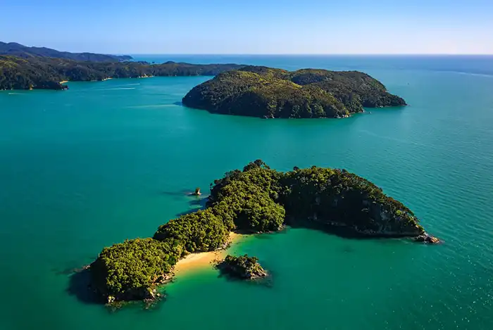 An aerial view of Fisherman Island in Abel Tasman with islands and secluded golden sand beach