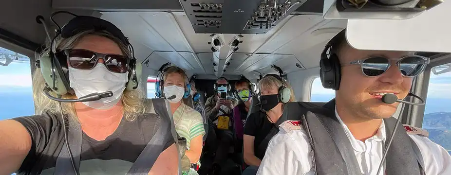 Passengers inside Golden Bay Air aircraft with a smiling pilot