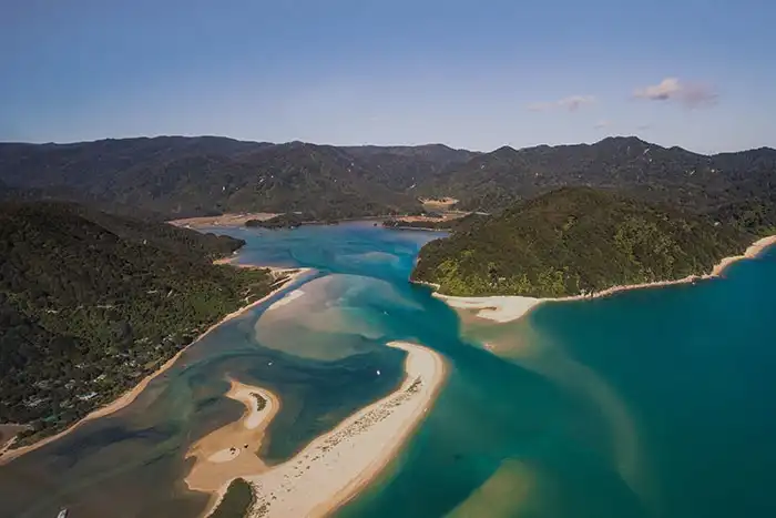 An aerial view over the moody blue and green hues Awaroa Inlet in the Abel Tasman National Park