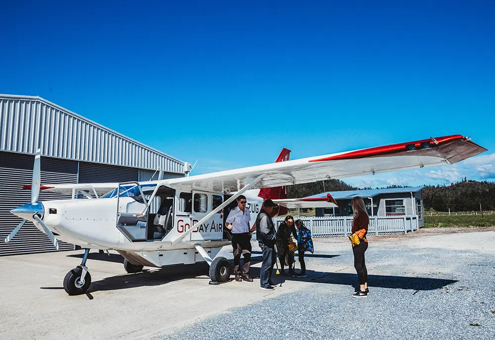 Pilot greeting passengers and directing them to board Airvan